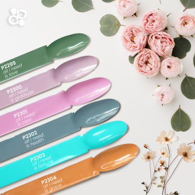 Seis colheres coloridas com frases e flores rosadas e verdes numa superfície branca.