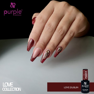 Mão feminina com unhas longas em verniz gel bordeaux e nude decoradas com pedras brilhantes