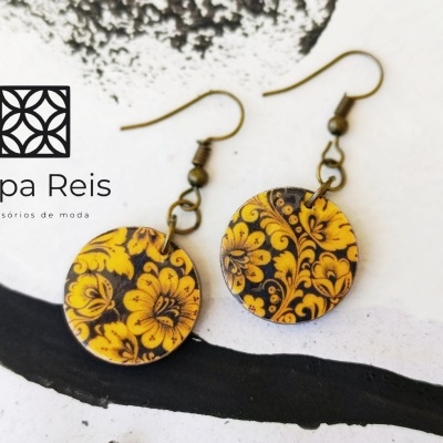 Brincos redondos amarelos com padrão floral preto e dourado
