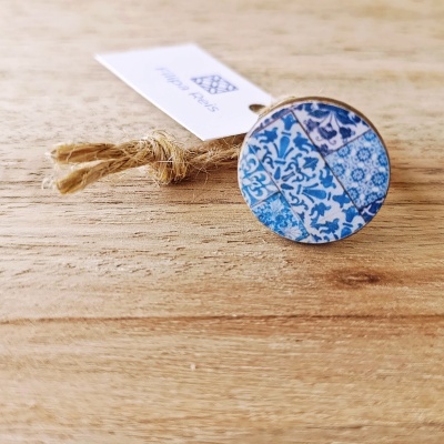 Anel azul com padrão de azulejos portugueses sobre superfície de madeira