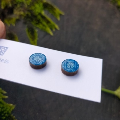 Brincos redondos azuis com padrão floral em cartão branco com texto Filipa Reis