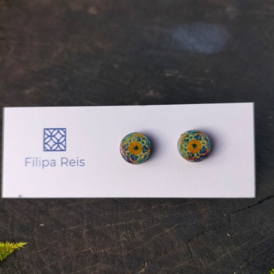 Brincos redondos coloridos com padrão sobre cartão branco com texto Filipa Reis