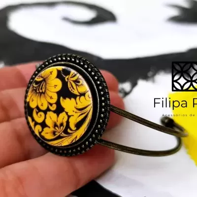 Pulseira metálica bronze com padrão floral amarelo e preto