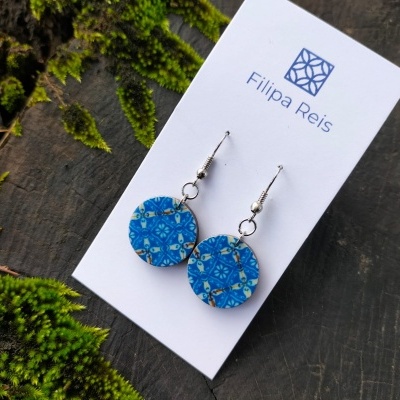 Brincos redondos azuis com padrão floral em cartão Filipa Reis sobre madeira com musgo