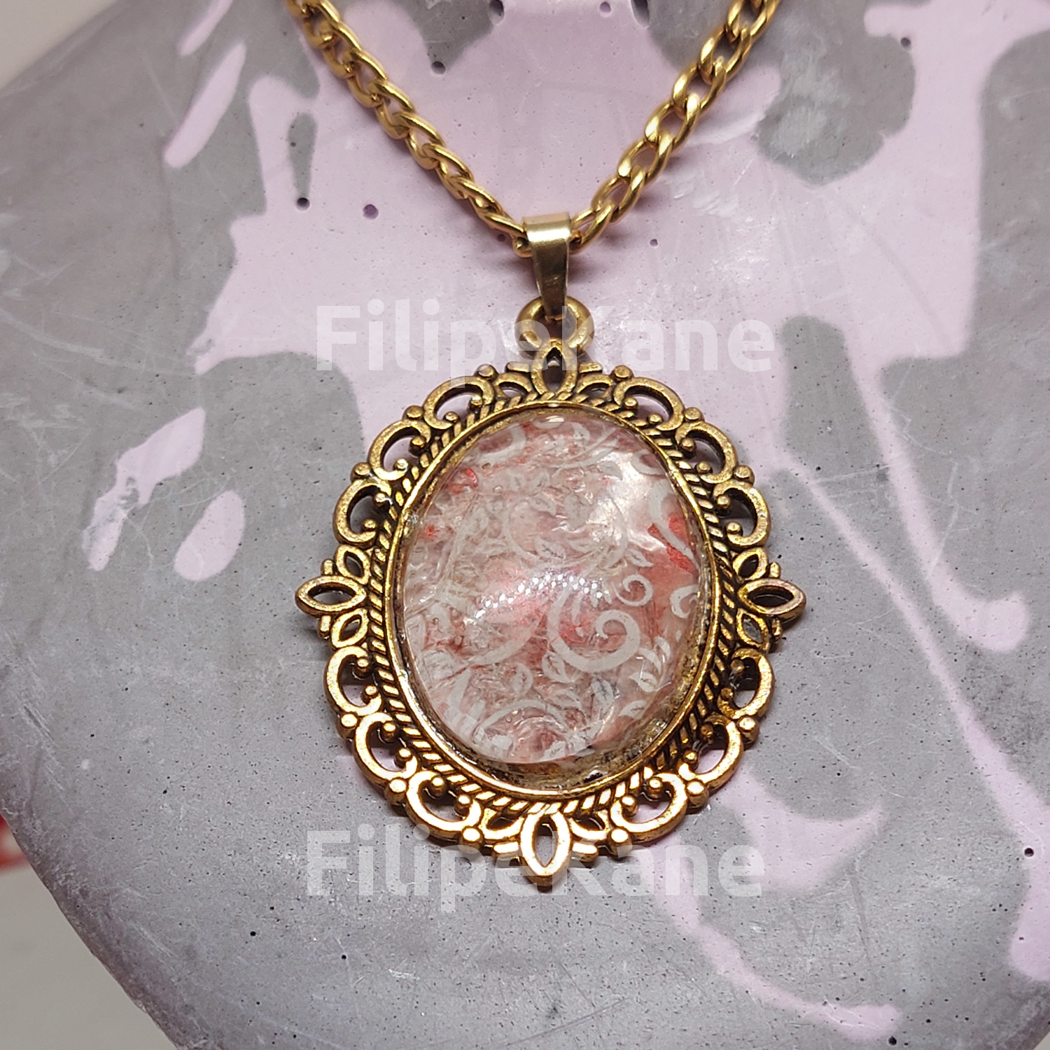 Colar com pendente oval dourado com padrão decorativo