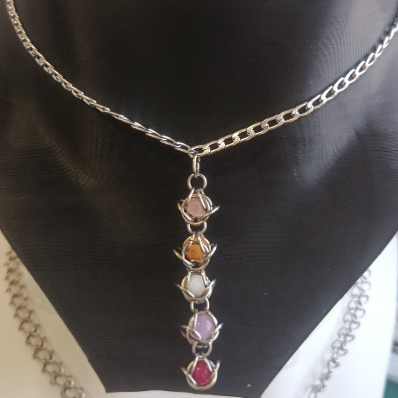 Colar prateado com pingente de cinco pedras coloridas envolvidas por metal