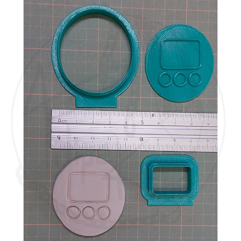 Peças para impressão 3D em plástico azul e cinzento com régua e fundo quadriculado.