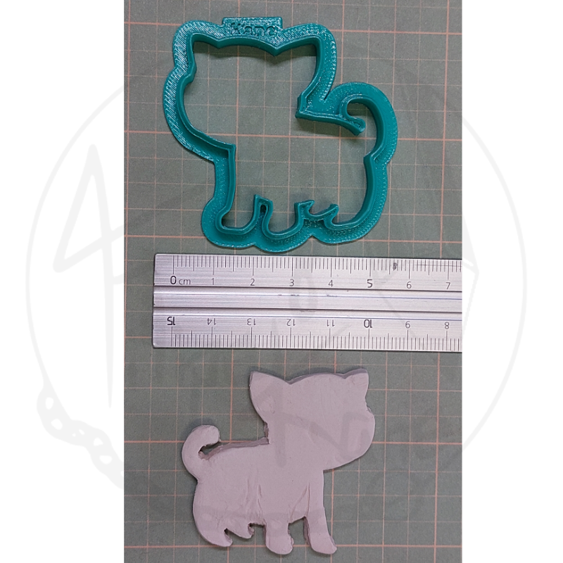 Cortador de biscoitos em forma de cão azul com molde branco e régua.