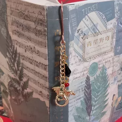 Marcador de livros dourado com corrente e pendentes, em livro decorativo com folha e partitura