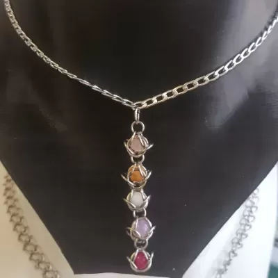 Colar prateado com pingente de cinco pedras coloridas envolvidas por metal