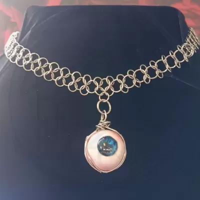 Colar prateado com pendente em forma de olho azul