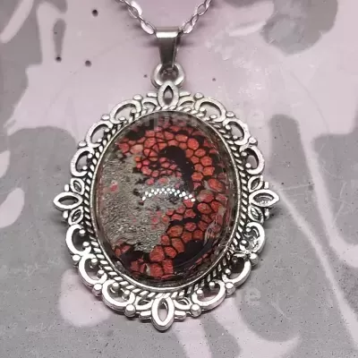 Colar com pendente oval de metal prateado e pedra com padrão abstracto vermelho e preto