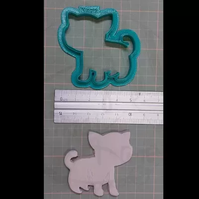 Cortador de biscoitos em forma de cão azul com molde branco e régua.