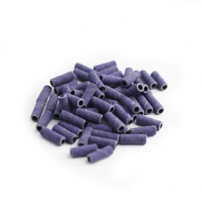 Tubos pequenos roxos com textura abrasiva sobre fundo branco