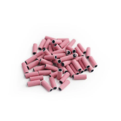 Tubos abrasivos cor de rosa com interior preto em pilha sobre fundo branco