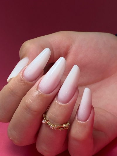 Unhas compridas em degradê branco com anel dourado com pérolas