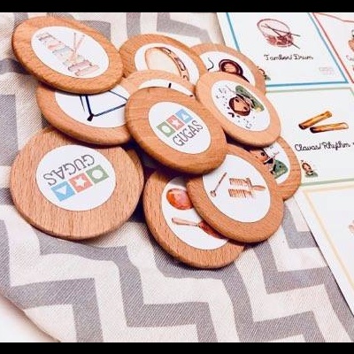 Peças de madeira redondas com ícones e cartas de papel sobre tecido cinza e branco