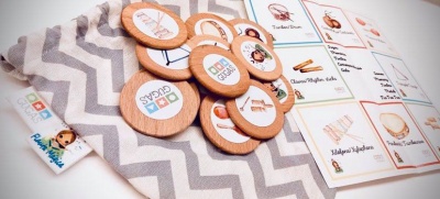 Peças de madeira redondas com ícones e cartas de papel sobre tecido cinza e branco