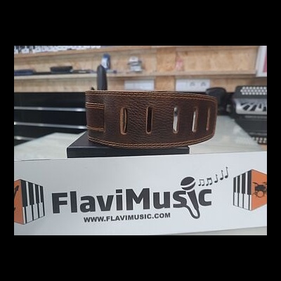 Correia de couro castanho para guitarra com cortes retangulares, sobre suporte com marca FlaviMusic