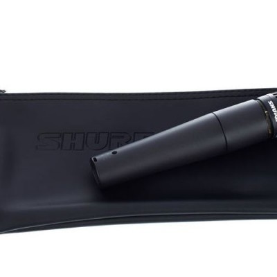 Microfone preto Shure com suporte, anilha dourada e saco preto de tecido