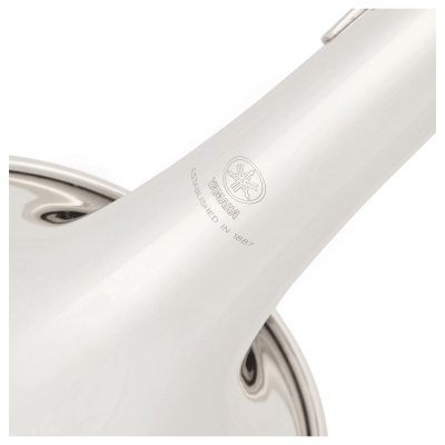 Instrumento musical de sopro branco com logo Yamaha e texto gravado.