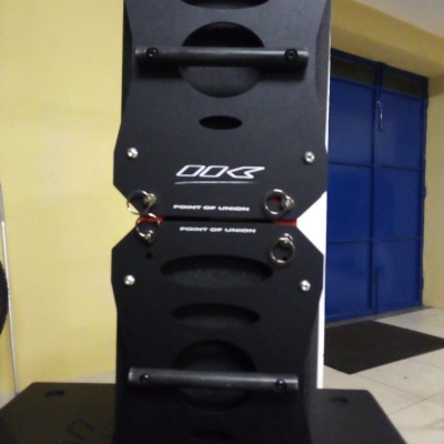Duas peças pretas com alças e texto DDK e POINT OF LIFTING num interior com porta azul