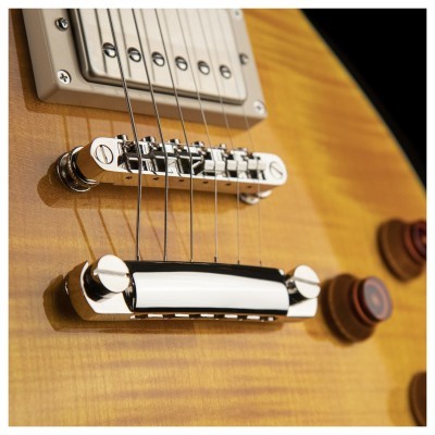 Corpo de guitarra elétrica em madeira clara com cordas e ponte cromada
