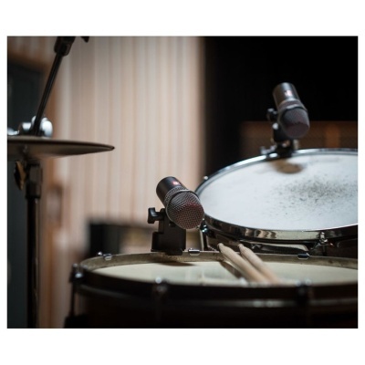 Bateria com tambor de caixa, prato, microfones e baquetas