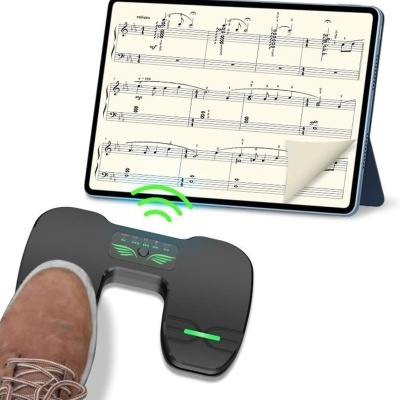 Pedal de controlo preto com luzes verdes e um tablet a mostrar partitura musical