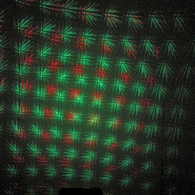 Padrão de luzes vermelhas e verdes em forma de estrelas numa superfície escura