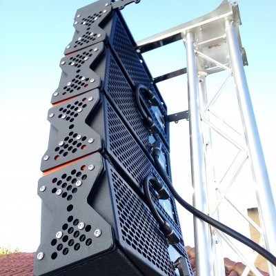 Coluna de altifalantes pretas suspensas numa estrutura metálica