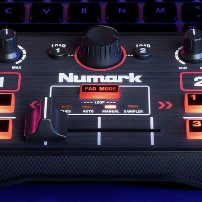 Equipamento DJ Numark preto com botões iluminados em vermelho e laranja