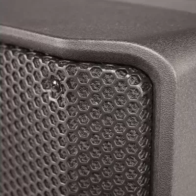 Pormenor de coluna sonora preta com grelha hexagonal e estrutura preta texturada