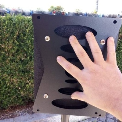 Painel táctil preto com recortes ovais e mão humana ao ar livre