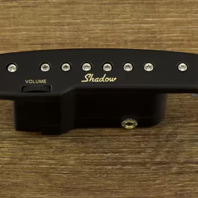 Captador para guitarra preto Shadow com seis botões e controle de volume sobre superfície de madeira