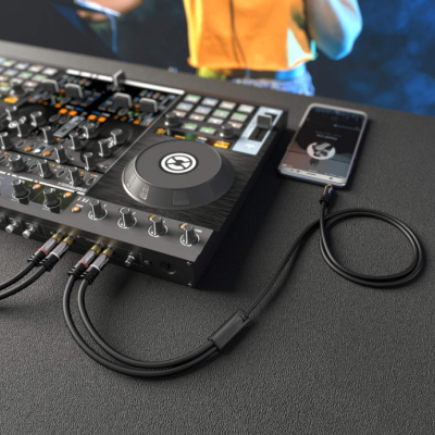 Equipamento de DJ com smartphone ligado por cabo sobre superfície preta