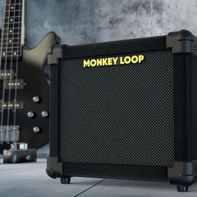 Amplificador de guitarra MONKEY LOOP preto junto a guitarra preta