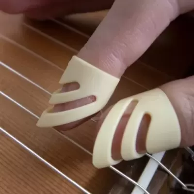 Dedais plásticos bege em dedos tocando guitarra clássica de madeira.