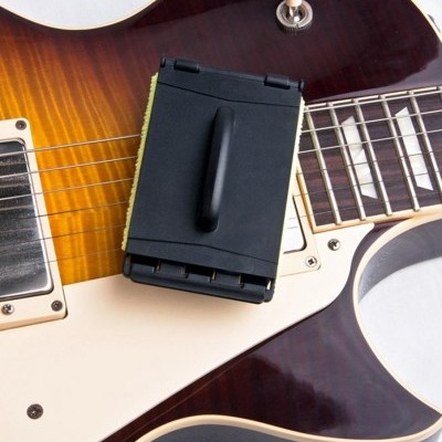 Guitarra elétrica sunburst com limpador preto sobre as cordas