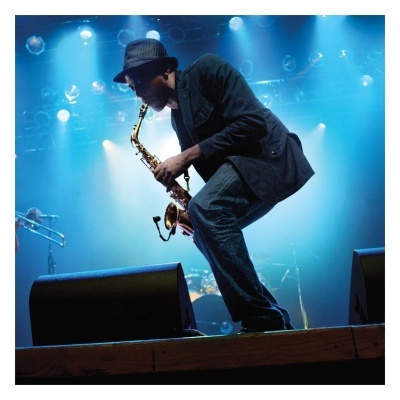 Músico a tocar saxofone numa palco com luzes azuis