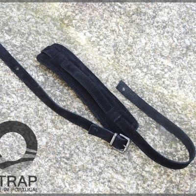 Correia preta de tecido com fivela metálica sobre superfície de pedra cinzenta