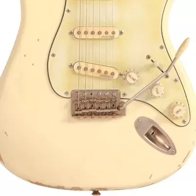 Guitarra elétrica off-white com marcas de desgaste e componentes metálicos