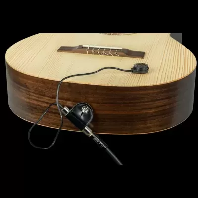 Guitarra acústica em madeira clara e escura com cabo de áudio ligado.