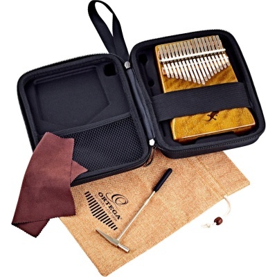 Kalimba em madeira clara com teclas metálicas, estojo preto, pano de limpeza castanho e saco de algodão