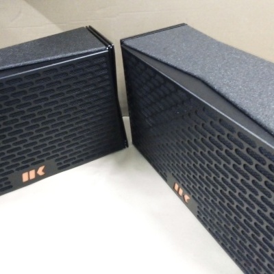 Caixas de colunas pretas com padrão de orifícios e detalhes laranja