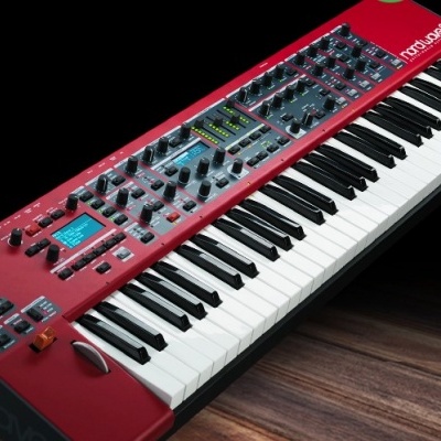 Teclado sintetizador vermelho com 61 teclas e visor digital azul sobre superfície de madeira