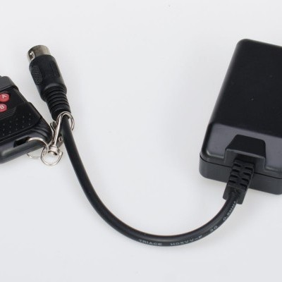 carregador preto com cabo e controlo remoto com botões vermelhos