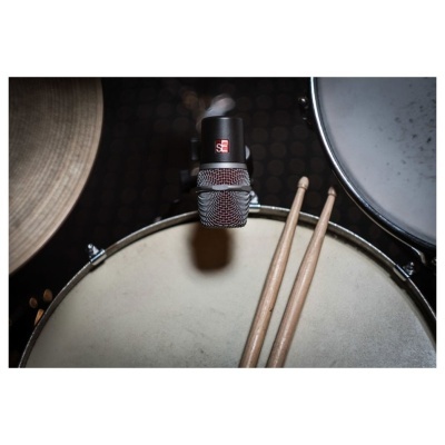 Microfone sobre pele de tambor com baquetas e pratos