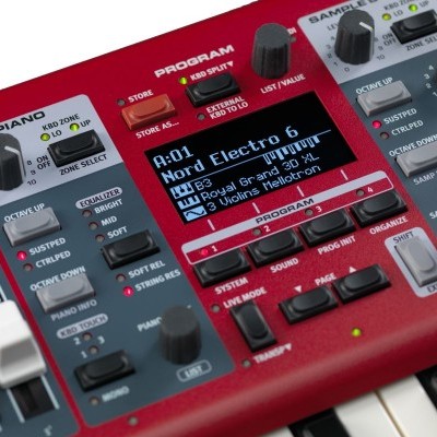 Teclado musical eletrónico vermelho com ecrã digital e múltiplos botões e teclas.