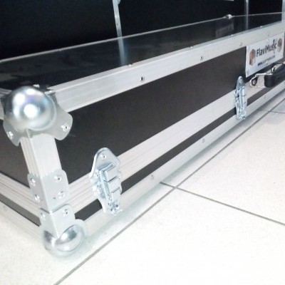 Mala rígida preta com bordas metálicas, reforços nos cantos e etiqueta FlamMobil